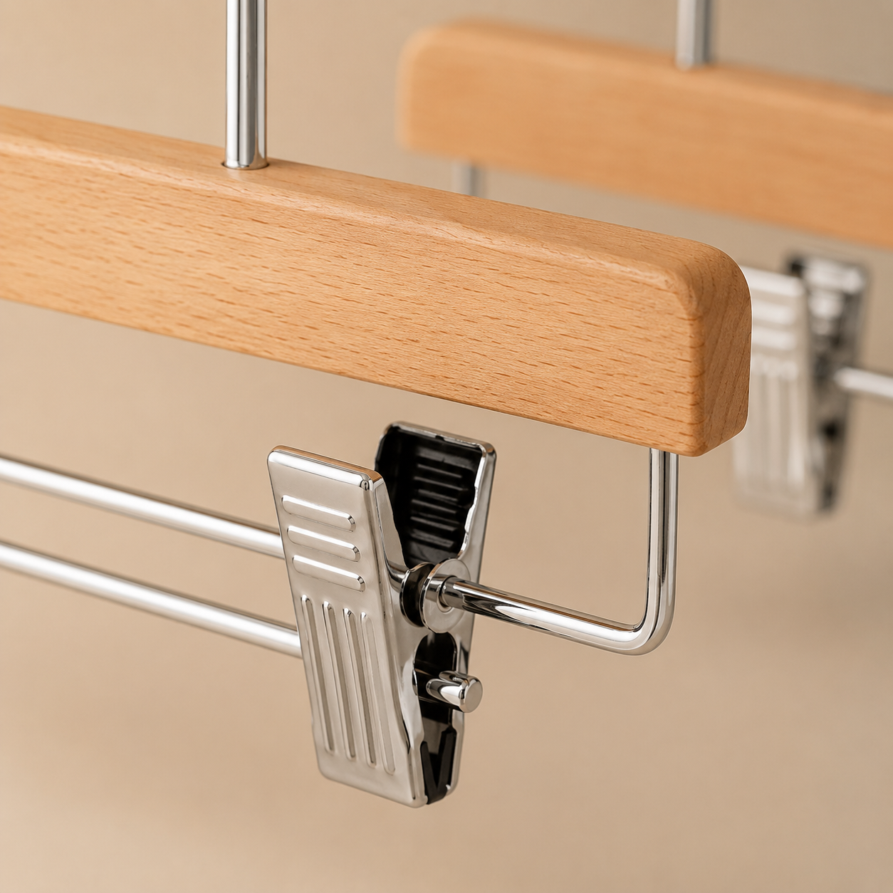 Close-up of adjustable chrome clip with rubber lining on a wooden trouser